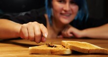 Ugh, That's Disgusting. Woman Found Big Cockroach In Peanut Butter Sandwich. Selective Focus Shot, Blurred Lady On Background, Reach Out Hand And Scary To Touch Bug Leg. Roach Jerks Its Paws