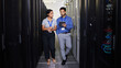 © Nina L/peopleimages.com - People, server room and teamwork on tablet, cybersecurity, engineering and programming or coding solution. Engineering man and woman or manager walking in data center, digital technology and training
