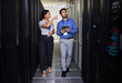 © Nina L/peopleimages.com - People, server room and inspection or teamwork for cybersecurity, engineering and coding solution on tablet. Engineering man and woman or manager walking and check data center with digital technology