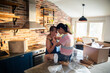 © Marko Geber - Young female lesbian couple hugging after moving in their new home apartment