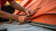 Tent Set-up: An image of hands securing tent poles and stakes