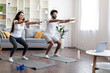 © Prostock-studio - Active indian couple practicing sports at home, making squats together