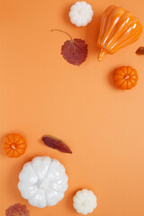 Wall Mural - Set of ceramic pumpkins and candles on orange background. Fall decor, interior decoration. Flat lay, top view, copy space