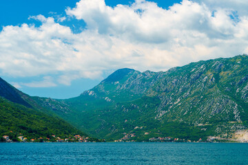 seascapes, a view of the Bay of Kotor during a cruise on a ship in Montenegro, a bright sunny day, mountains and small towns on the coast, the concept of a summer trip