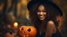 Beautiful Smiling African American Woman In Black Hat With Carved Halloween Pumpkin In Autumn Forest