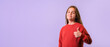 © KiNOVO - Girl wearing red sweater doing happy thumbs up. Looking at the camera with showing success. over isolated background