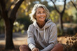 © Michael - an elderly beautiful woman of 50 years old with gray white hair, a wide smile, in an hoodie in the park
