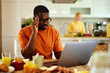 © Stockphotodirectors - Pensive black man working on laptop during breakfast at home