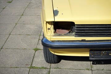 Wall Mural - Altes zweitüriges Coupé der Kleinwagen Klasse in hellem Gelb oder Beige der Siebzigerjahre vor einer modernen Garage in Bielefeld im Teutoburger Wald in Ostwestfalen-Lippe