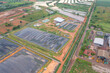 © tampatra - Aerial view of stack of different types of large garbage pile, plastic bags, and trash with a tractor car in industrial factory in environmental pollution. Waste disposal in dumping site.