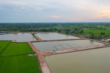 Aerial view of local fishing trap net in canel with fisherman home, lake or river at sunset. Nature landscape fisheries and fishing tools lifestyle at Pak Pha,Phattalung, Thailand. Aquaculture farming