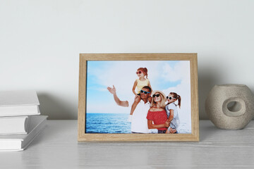 Wall Mural - Frame with family photo, books and other decor element on white wooden table indoors