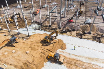 Wall Mural - Construction site of a large warehouse storage building and logistics center, heavy vehicle working, excavator, crane, truck and bulldozer, steel frame structure of modern factory hangar, aerial view