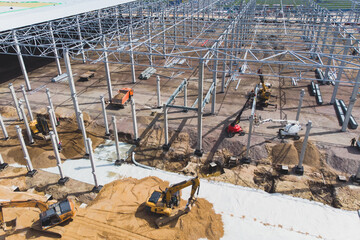 Wall Mural - Construction site of a large warehouse storage building and logistics center, heavy vehicle working, excavator, crane, truck and bulldozer, steel frame structure of modern factory hangar, aerial view