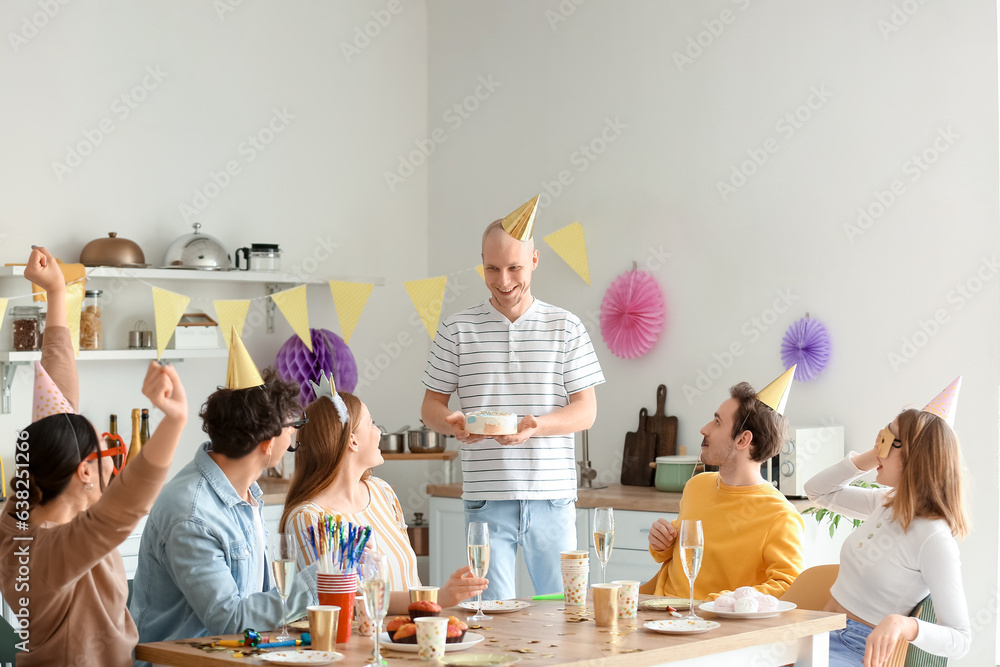 Group of young friends celebrating Birthday in kitchen