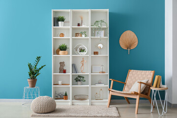 Interior of room with chair, shelving unit and stylish holder for books on table