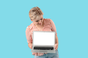 Happy young female programmer with laptop on blue background