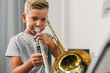 © cherryandbees - Young boy practicing trombone alone.