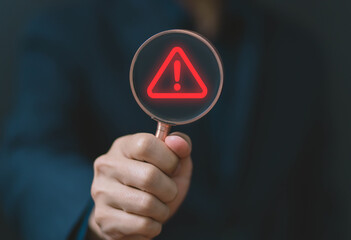 Wall Mural - businessman using laptop showing warning triangle and exclamation sign icon warning of dangerous pro