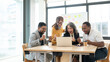 © bongkarn - A group of cheerful, diverse startups is looking at a laptop screen with an excited face