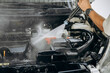 © Berezhna_Iuliia - Washing the car engine under strong water pressure. Car maintenance, care and cleanliness. Worker cleaning. Vehicle washes, cleaning, car service concept.