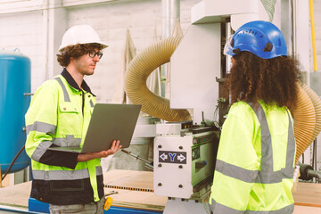 Portrait of an engineering team of men and women in safety uniforms. Use computers to check and control machinery in industrial plants.