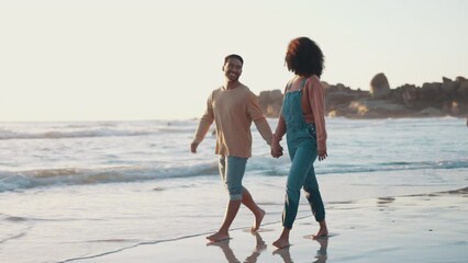 Poster - Happy, interracial couple and walking at beach for summer, holiday, tropical vacation or sunset date. Man, woman and holding hands to walk at sea, nature ot relax for travel, freedom or love at ocean