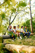 © master1305 - Cheerful playful kids sitting on log in forest on sunny day. Going hiking, walking, having active weekends. Concept of leisure activity, childhood, summer, friendship, active lifestyle, fun, nature