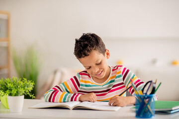 Wall Mural - Photo of smart pupil kid sitting table writing notebook doing class project assignment in modern school