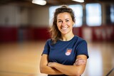 Portrait of smiling female volleyball player with crossed arms in squash court