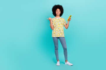 Sticker - Photo of funny satisfied afro girl blogger wear stylish outfit arm direct empty space cool offer advice isolated on cyan color background