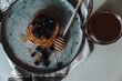 Minimalistyczne ujęcie domowych naleśników z miodem i owocami na pięknym talerzu. 