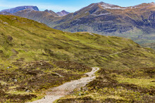 A Hiking Trail Heading Towards Spectacular Mountains With Traces Of Summer Snow (Ben Nevis And Range, Scotland)