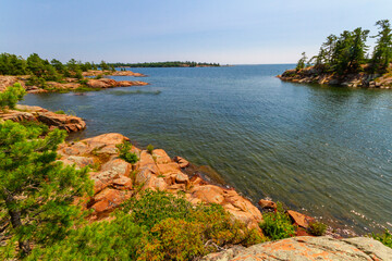 Shoreline along lake Huron. Granite Red rocks at the mouth of the Chikanishing Creek. Georgian Bay. Killarney Provincial Park, Ontario, Canada