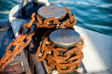 Old Abandoned Anchor Chain With Rust And Iron Cleat,  On A Post In A Sea Dock
