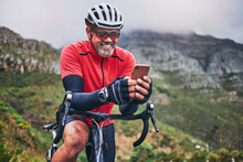 Happy Man, Cyclist And Phone On Mountain Bicycle In Communication, Social Media Or Networking In Nature. Male Person Or Athlete Smile On Mobile Smartphone App In Sports Workout, Fitness Or Cycling