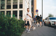 © BullRun - Stylish man holding cute dog on leash while standing on street