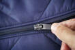 Closeup shot of a zipper on a blue jacket. Unzip a zip
