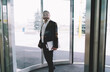 © BullRun - Businessman in suit entering office door
