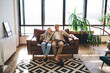 © BullRun - Cheerful senior couple resting on couch in living room
