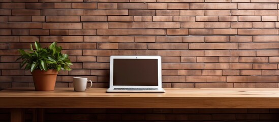 Beautiful interior of a house with a computer on a wooden table and a brick wall background