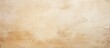 © HN Works - Close up of a vintage brown paper texture on a plain cream color cement wall showcasing beige and light brown shades of natural stone