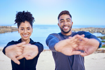 Portrait, beach and couple stretching, fitness and exercise with training, warm up and runner with wellness. Healthy people, man and woman stretch, seaside and workout with sports, ocean and energy