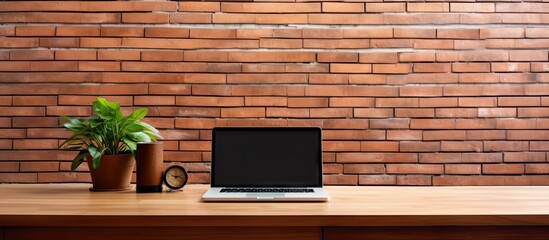 Beautiful interior of a house with a computer on a wooden table and a brick wall background
