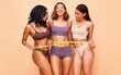 © Anela/peopleimages.com - Girl friends, underwear and measuring tape in studio portrait for laugh, wellness and diversity by background. Women group, healthy body and lingerie to lose weight, help or transformation with pride