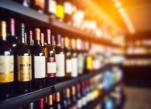 Abstract Blur Wine Bottles On Liquor Alcohol Shelves In Supermarket Store Background.