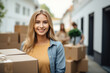 Happy smiling girl carrying cardboard box with belongings. Female student moving out of parents house. Young woman moving to dorm, new apartment, rent a flat