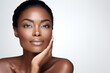 © Alicia - Gorgeous black woman touching her cheek, natural light, skincare advertisement, on a white background, cosmetology concept