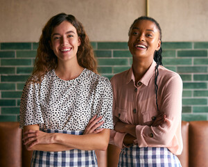 Portrait Of Two Smiling Female Owners Or Staff Working In Restaurant Or Coffee Shop