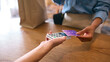 © Monkey Business - Close Up Of Female Customer In Fashion Store Paying For Clothes With Contactless Card Payment